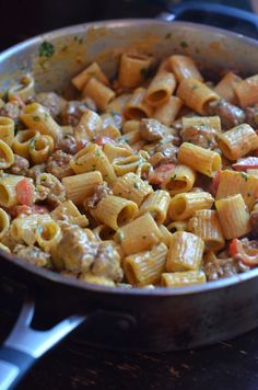 a pan filled with pasta and meat on top of a stove