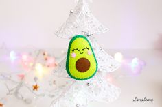 an avocado ornament hanging from a christmas tree