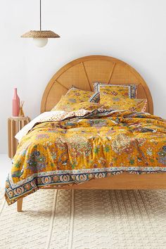 the bed is made up with yellow and blue comforters, pillows, and blankets