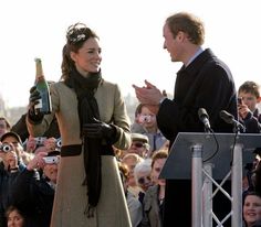 a man and woman standing next to each other in front of a crowd