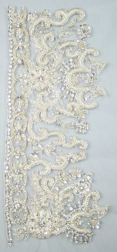 white lace with beading and sequins on a light blue background