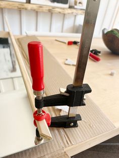 a pair of scissors are sitting on top of a piece of wood that is being worked on