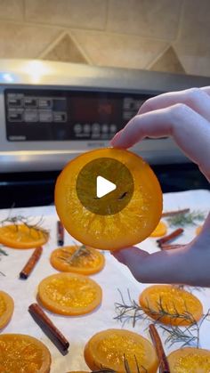 a person is holding an orange in front of some cinnamons on a counter top