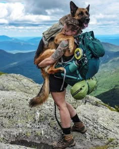 a woman holding a dog in her arms on top of a mountain with the caption instagram