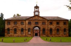 an old brick building with a clock on the top of it's tower and arched doorway