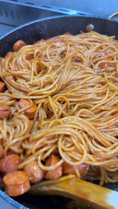 noodles and carrots are being cooked in a skillet