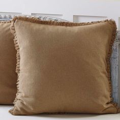 two brown pillows sitting on top of a bed