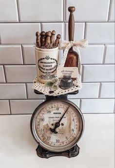 an old fashioned clock with spices on it and a bottle sitting on top of it