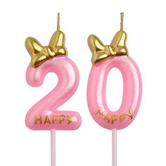 pink and gold birthday candles with the number 20 on them, decorated with a bow