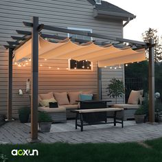 an outdoor living area with patio furniture and string lights on the pergolated roof