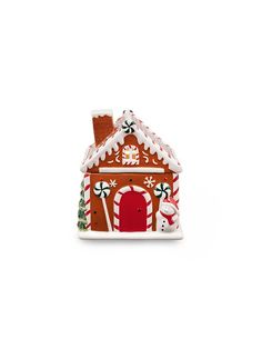 a ceramic gingerbread house ornament is shown on a white background with snowflakes and candy canes