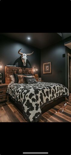 a large bed sitting in a bedroom next to a cow skull on top of a wall