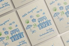 several business cards with blue ink on white paper, each featuring an image of a building and umbrellas