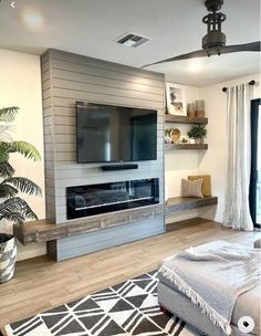 a living room with a large flat screen tv on the wall and a couch in front of it