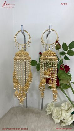 two gold earrings with pearls hanging from them