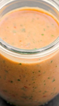 a jar filled with sauce sitting on top of a table