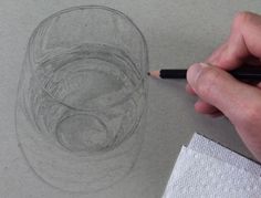 someone is drawing something with pencils on the paper and it looks like a cup