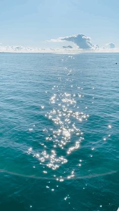 the back end of a boat in the ocean with bright sunlight reflecting off the water