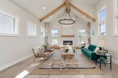 Cozy Family Room in High Ceiling Farmhouse Great harmony between the green sofa and wooden details such as stools, coffee table, and armchairs! Sam Snead, Dark Wooden Floor, Farmhouse Tv, Wooden Fireplace, Texas House