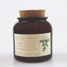 a glass jar filled with brown liquid on top of a white table next to a cork lid