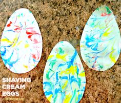 three painted eggs sitting on top of a counter next to the words shaving cream eggs