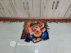 an elephant is painted on the floor next to some cupboards and drawers in a kitchen