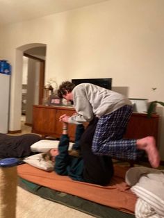 two people are doing yoga in the living room with their feet on each other's legs