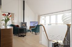 a living room filled with furniture and a flat screen tv sitting on top of a wooden floor