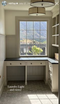 an empty kitchen with white cabinets and windows