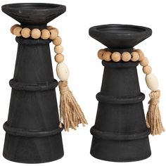 two black candlesticks with beads and tassels