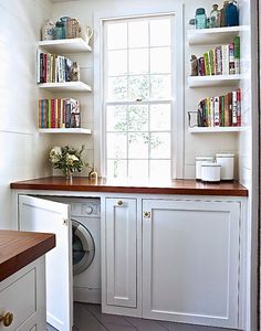 a washer and dryer in a room with bookshelves on the wall