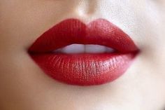 a woman's lips with bright red lipstick on top of her face and bottom lip