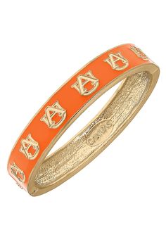 an orange and gold bang bracelet with letters on the side, in front of a white background