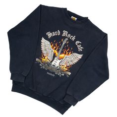 Super unique vintage Hard Rock Cafe sweater, with an amazing guitar with wings print and flames in the background. The black color is slightly faded. Brand: Hard Rock Café Material: 80% Cotton, 20% Polyester Measurements: (taken from seam to seam while the garment is lying flat) Armpit to armpit: 51 cm Top of shoulder to bottom: 65 cm Sleeve length from edge collar down: 72 cm Sleeve length from armpit: 50 cm Tag Size: Small Size Estimated: Unisex Small - Welcome to Luna Ravi Vintage! This is a small business, located in the Netherlands. At Luna Ravi Vintage you will find the most unique pieces of clothing, handmade accessories and beautiful interior pieces. The style is a mix of whimsical, hippie, grunge and cottagecore. The clothing items that are sold are vintage and have been owned and Hard Rock Cafe Sweater, Vintage Hard Rock Cafe Sweatshirt, Hard Rock Café, Cafe Vintage, Hippie Grunge, Black Sweatshirt, Rock Cafe, Hard Rock Cafe, Print Pullover