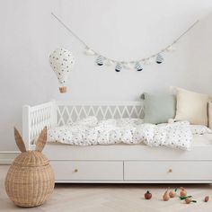 a white bed sitting in a bedroom next to a wooden table and toy animals on the floor