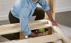 a man is working on some wood with a drill and screwdriver in his hand