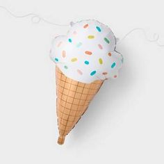 an ice cream cone with sprinkles hanging from it's side on a white wall