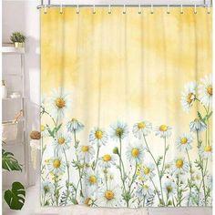 the shower curtain is decorated with daisies