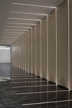 an empty room with black and white marble flooring in the foreground is illuminated by light