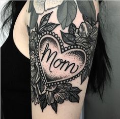 a black and white photo of a woman's arm with a tattoo on it