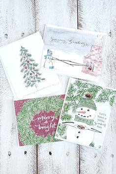 four christmas cards on top of each other, one with a snowman and the other with a tree