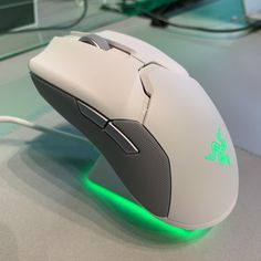 a close up of a computer mouse with green light on the bottom and side buttons