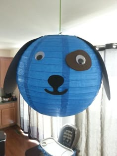 a blue dog shaped paper lantern hanging from a ceiling