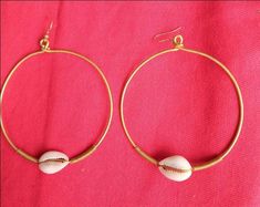 The earrings are  made with a lot of love and care from shell and brass. The brass coated wire is wrapped to give a stunning look.  The are  beautifully designed for you, sister, mother, relative or a friend. The are light in weight and comfortable to wear. **This listing is for 10 pairs of earrings as shown.** Buy multiple items pay shipping for one the rest ships free. Custom orders are welcome.   For more earrings, follow the link. https://www.etsy.com/listing/697317594/african-earrings-gift-for-her-earrings?ref=related-1 **Happy shopping** Dhl shipping express Thank you. Gold Hand Wrapped Jewelry For The Beach, Beach Gold Hand Wrapped Jewelry, Handmade Hoop Earrings For The Beach, Gold Metal Hoop Earrings For Beach, Unique Gold Shell Earrings, Gold Cowrie Shell Jewelry For Gift, Shell-shaped Brass Jewelry For The Beach, Brass Shell Jewelry For Beach, Beach Shell Brass Jewelry