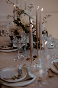 the table is set with candles, plates and silverware for an elegant wedding reception