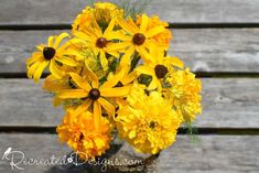 a vase filled with yellow flowers on top of a wooden table