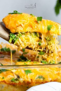 a casserole with broccoli and cheese being lifted from the casserole dish