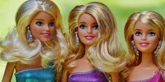 three barbie dolls with blonde hair and blue eyes are standing side - by - side