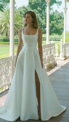 a woman in a white dress standing on a porch