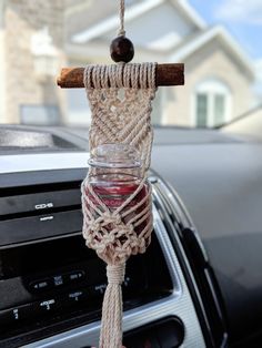 a car dashboard with a glass jar hanging from it's handle and rope attached to the dash board